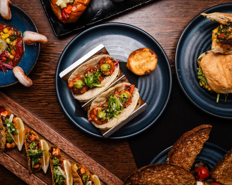 Two poke tacos standing in a holder with crostini