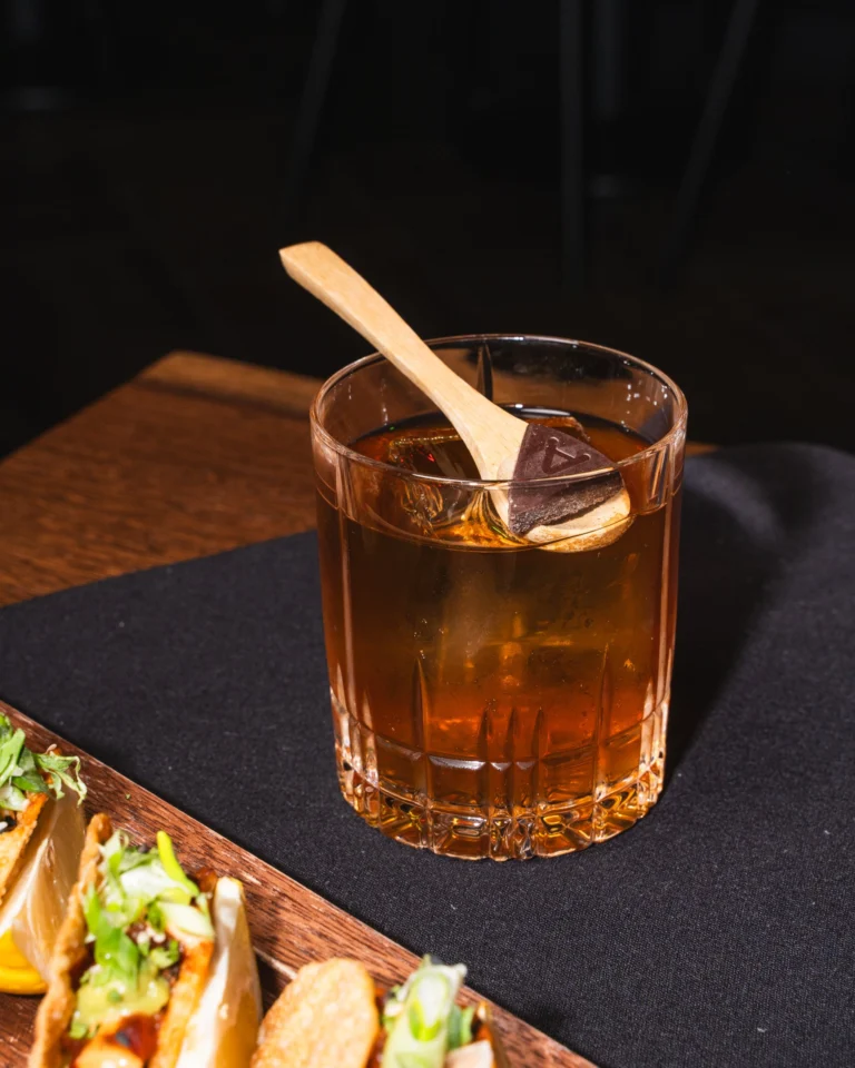 A smoked old fashioned with a cinnamon stick in a rocks glass